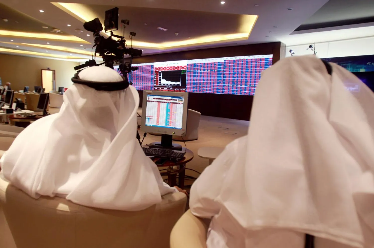 Traders monitor screens displaying stock information at Qatar Stock Exchange in Doha, Qatar June 5, 2017. REUTERS/Stringer/File Photo
