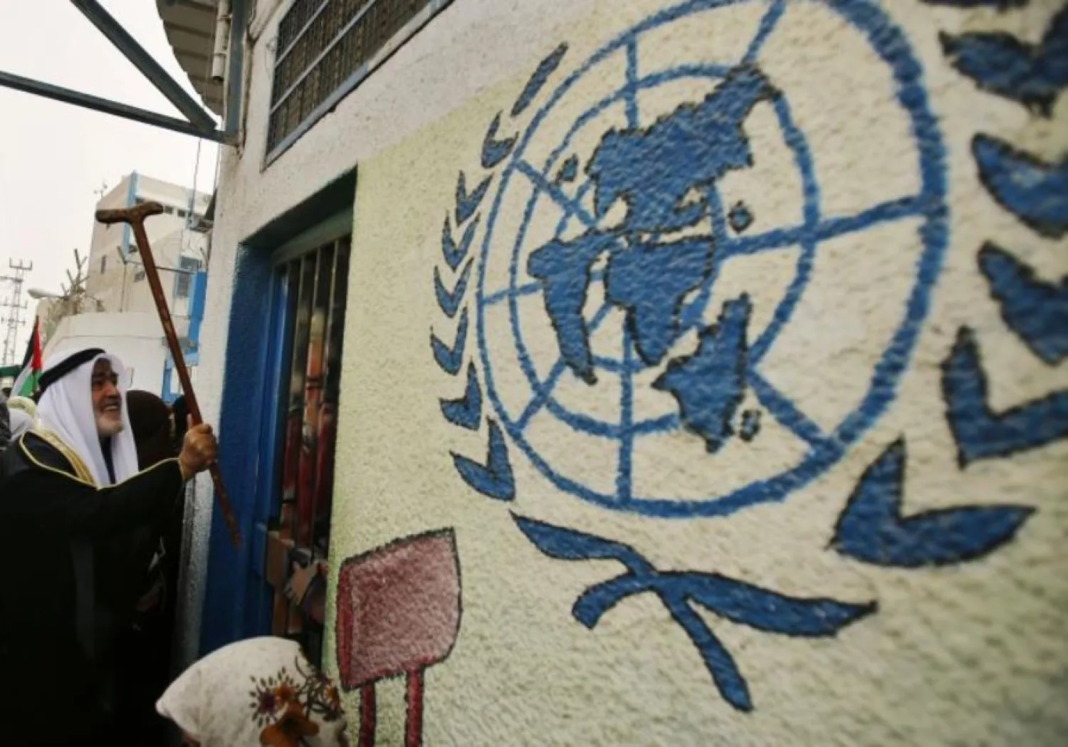 Palestinian refugee knocks on the closed gate of the United Nations Relief and Works Agency (UNRWA) headquarters with his walking stick. (photo credit:REUTERS)