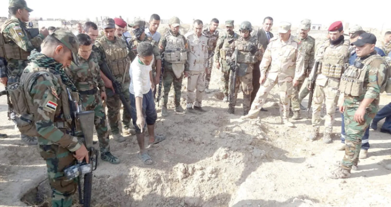 القوات العراقية تتحرى موقعاً يشتبه أنه قبر جماعي لضحايا «داعش» جنوب غربي الحويجة أمس (أ.ف.ب)