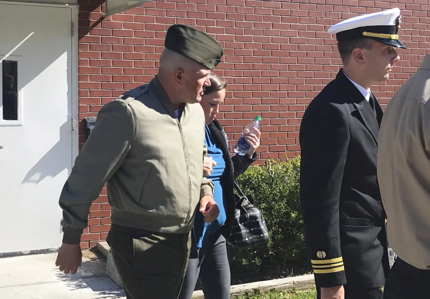 In this Oct., 31, 2017 file photo, US Marine Gunnery Sgt. Joseph A. Felix, his wife, and his lawyers exit a courtroom after testimony at Camp Lejeune, N.C. (Rory Laverty /The Washington Post/via AP, File) 