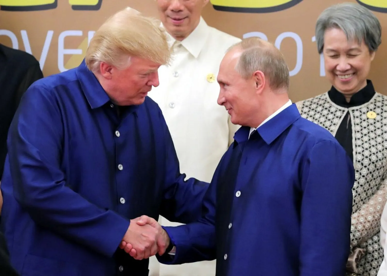 US President Donald Trump and Russian President Vladimir Putin shake hands as they take part in a family photo at the APEC summit in Vietnam. (Reuters)