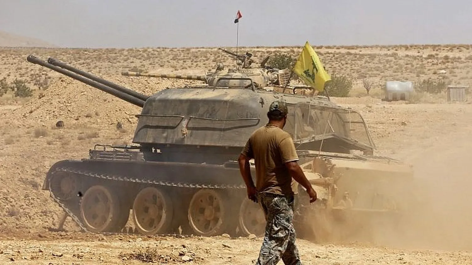 A tank flying the Hezbollah terror group's flag is seen in the Qara area in Syria's Qalamoun region on August 28, 2017.(AFP Photo/Louai Beshara)
 