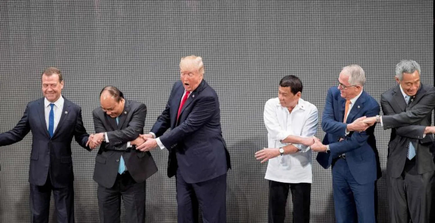 سلسلة المصافحة خلال التقاط الصورة التذكارية للقادة المشاركين في قمة آسيان (أ.ف.ب)