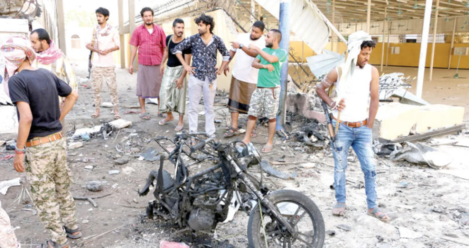 يمنيون أمام موقع شهد تفجيراً انتحارياً تسبب في مقتل ستة من رجال الأمن في مدينة عدن أمس (إ.ب.أ)