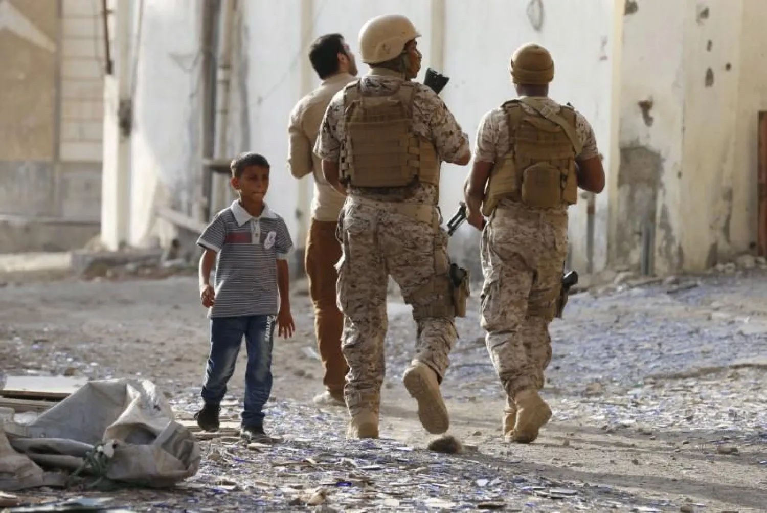  A boy walks past soldiers from the Saudi-led coalition patrolling a street in Yemen's southern port city of Aden September 26, 2015. REUTERS/Faisal Al Nasser