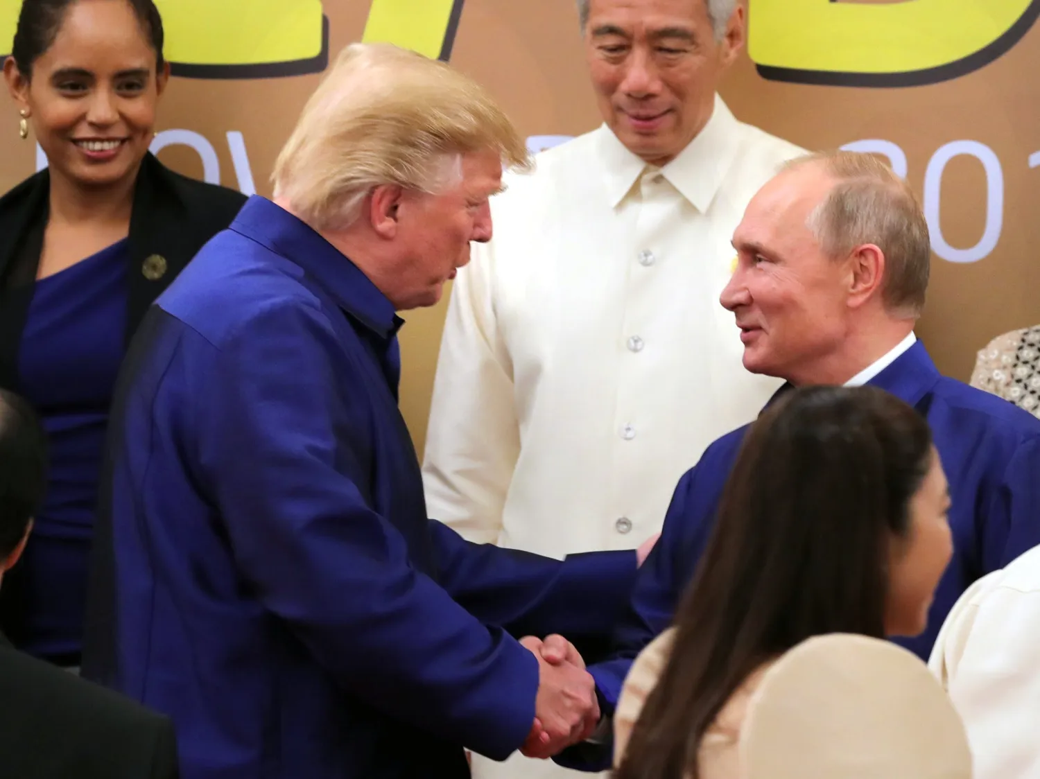 Donald Trump shakes hands with Russia’s President Vladimir Putin as they pose for a group photo ahead of the Asia-Pacific Economic Cooperation Summit in Da Nang, Vietnam on Nov. 10, 2017. (Credit: Mikhail Klimentyev/AFP/