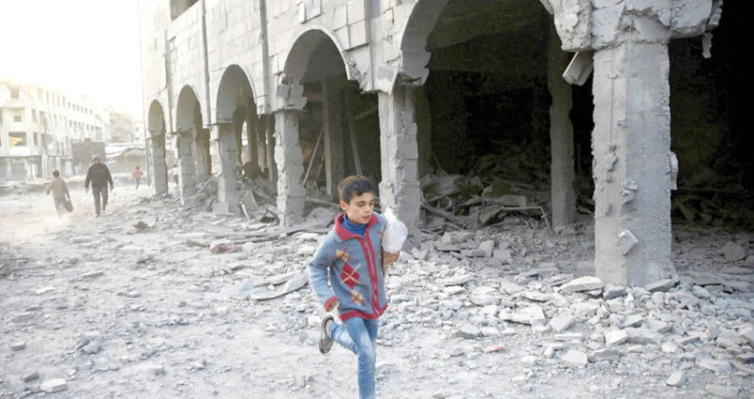 طفل يمر قرب بناء دمر جراء قصف قوات النظام شرق دمشق (رويترز)