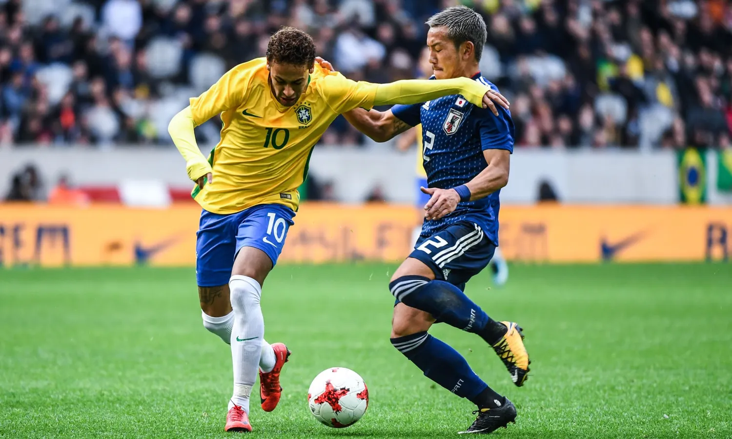 Neymar of Brazil and Japan’s Ideguchi Yosuke tussle during the international friendly in Lille. Photograph: Anthony Dibon/Icon Sport via Getty