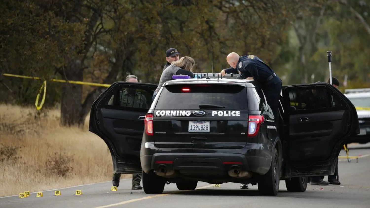 Law enforcement officers and a crime scene photographer examine a police vehicle that was involved in a shooting in the morning on November 14, 2017, in Rancho Tehama.(AFP Photo)