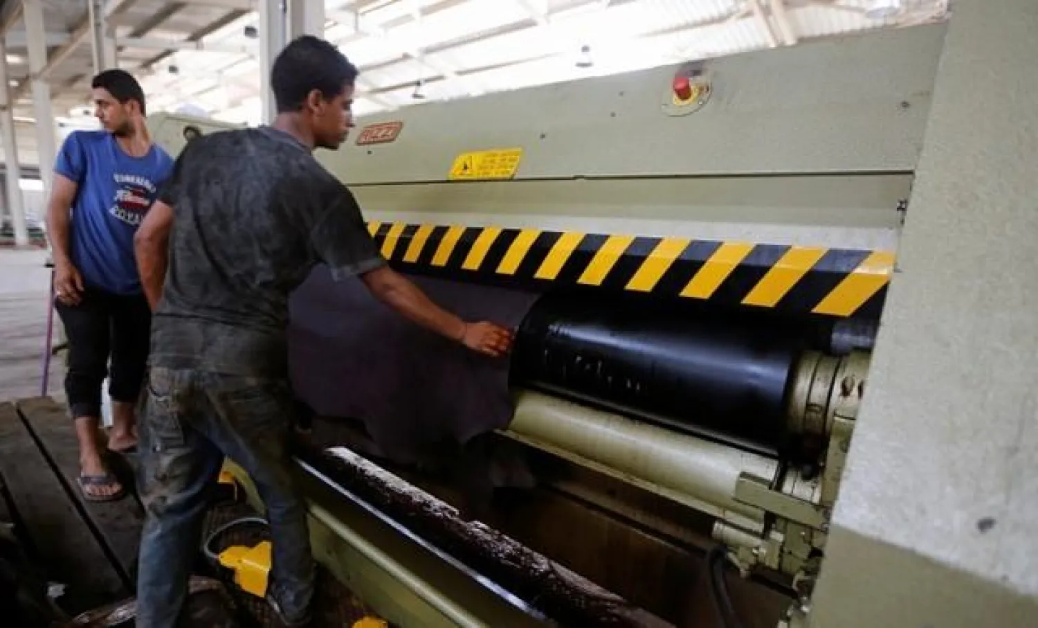Workers remove leather from a machine in the factory at El Robbiki Leather City in Badr City, east of Cairo, Egypt, August 14, 2017. REUTERS/Amr Abdallah Dalsh