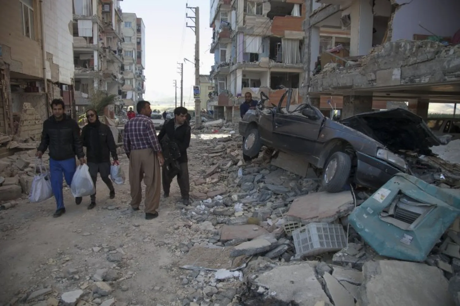 Residents look at the damage following the earthquake in Sarpol-e Zahab in Iran's western province of Kermanshah on November 13, 2017. FARZAD MENATI/AFP