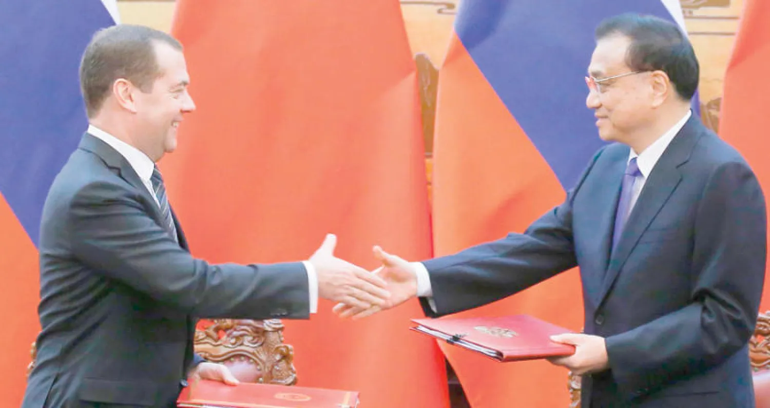 رئيس الوزراء الصيني لي كيبيانغ (يمين) مع نظيره الروسي ديمتري ميديفيديف خلال لقاء في بكين يعكس التقارب بين بكين وموسكو (أ.ف.ب)