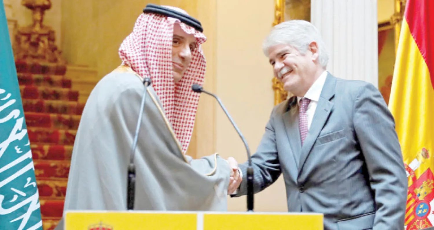 وزير الخارجية السعودي مصافحا نظيره الإسباني بعد لقاء عقد في مدريد أمس (إ.ب.أ)
