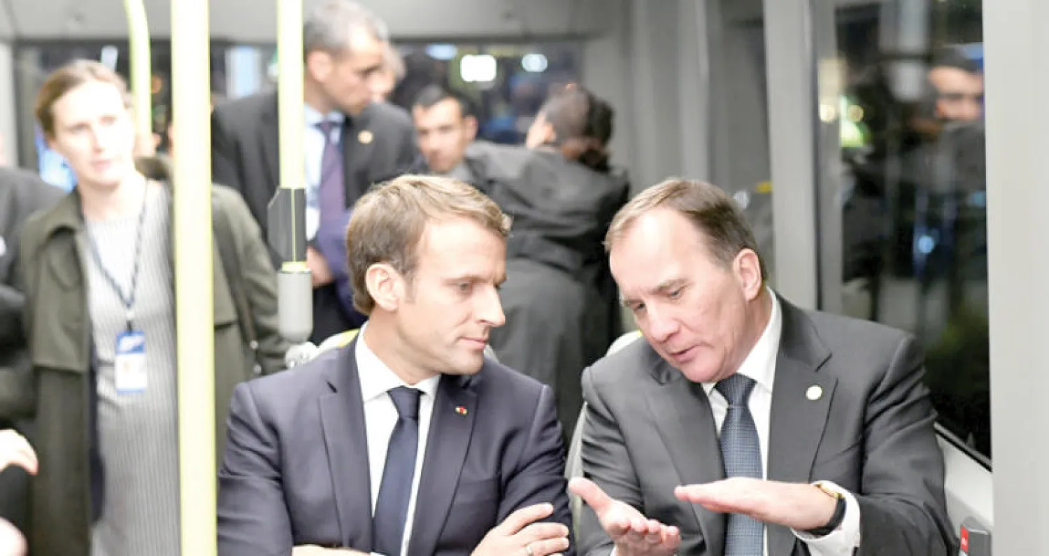 الرئيس الفرنسي مع رئيس الوزراء السويدي أثناء زيارتهما لمصنع سيارات فولفو في غوتنبرغ السويدية أمس (رويترز)