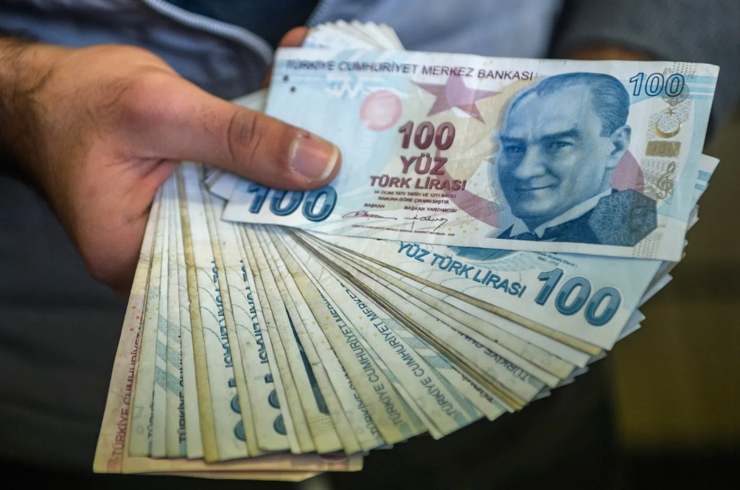 A change office staff shows Turkish lira on his hand on December 2, 2016 in Istanbul. Photo: Ozan Kose / AFP