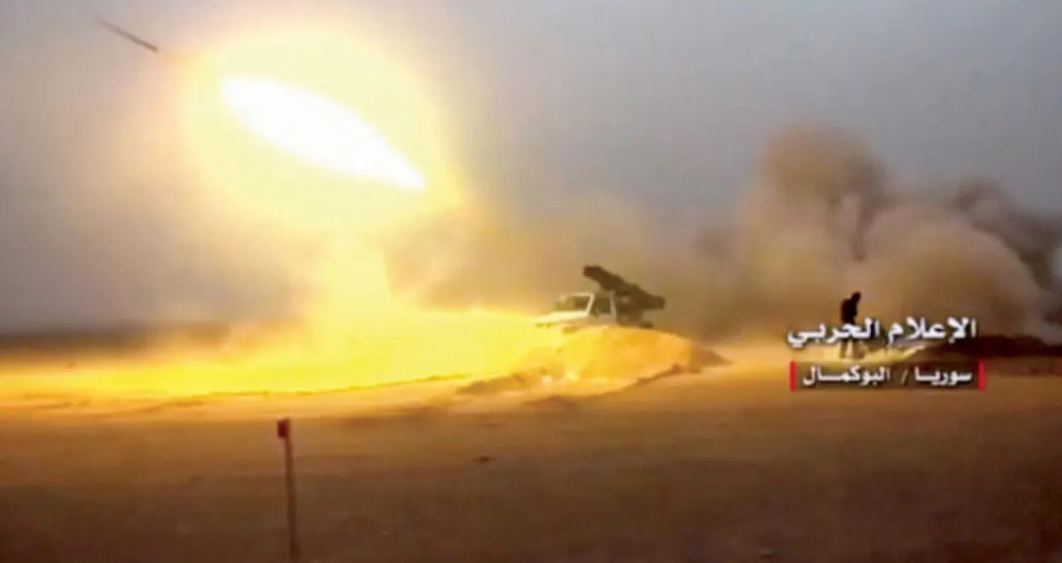 عربة عسكرية تابعة لقوات النظام تطلق قذيفة في البوكمال (رويترز)