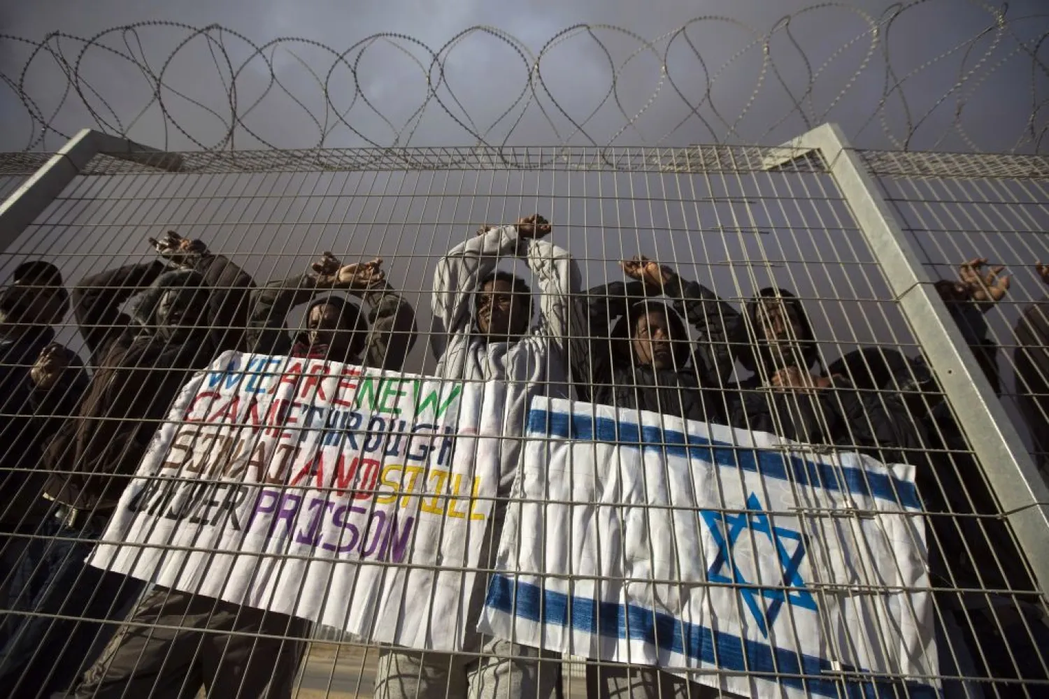 African migrants gesture behind a fence during a protest against Israel's detention policy towards them, at Holot, Israel's southern Negev desert detention center February 17, 2014.
REUTERS / AMIR COHEN