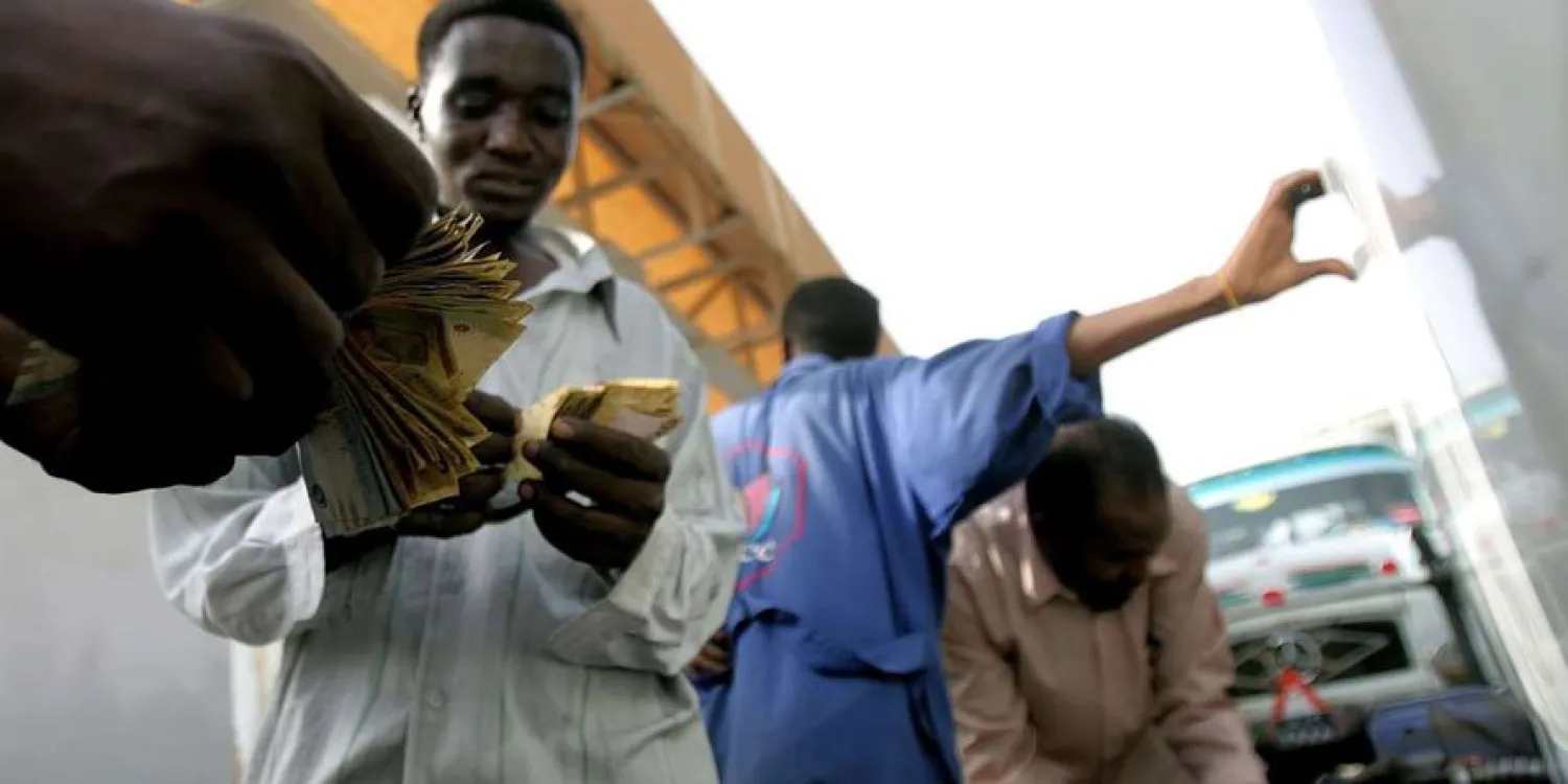 A Sudanese man pays for fuel after filling his vehicle at a petrol station in the capital Khartoum on June 21, 2012. file photo | AFP 