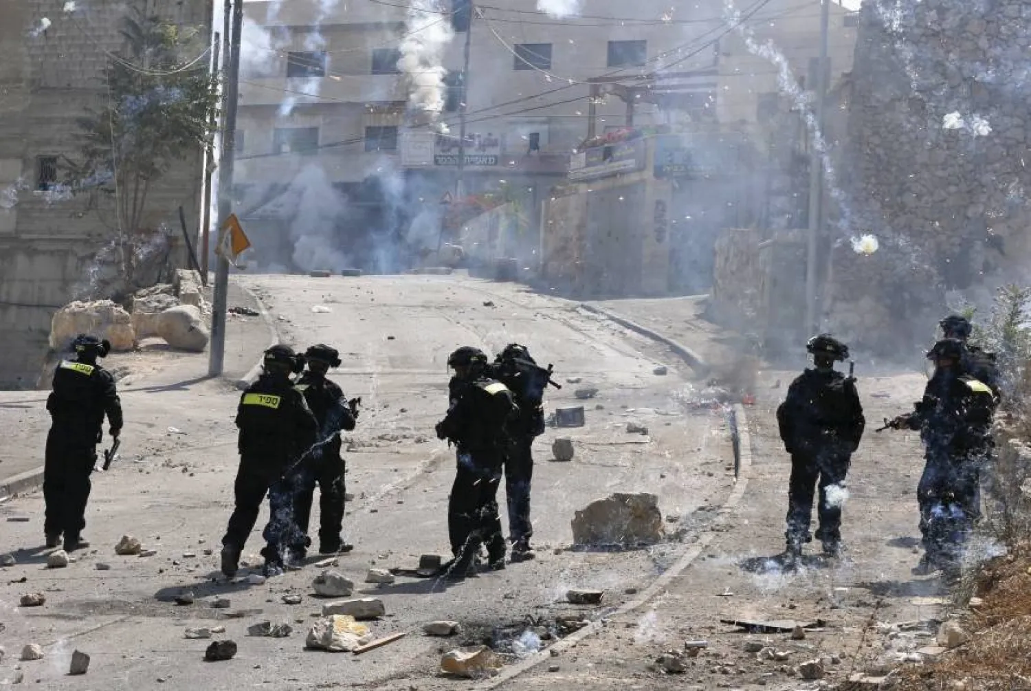 Fireworks descend near Israeli police officers during clashes with Palestinian protesters in the East Jerusalem. (Reuters)