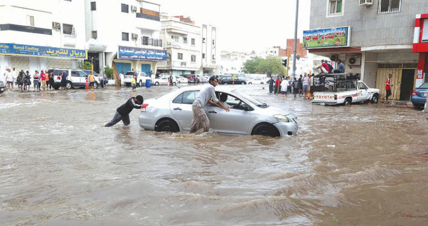 متطوعين يساعدون السيارات العالقة في أحد شوراع مدينة جدة (تصوير: سليمان المرزوقي)