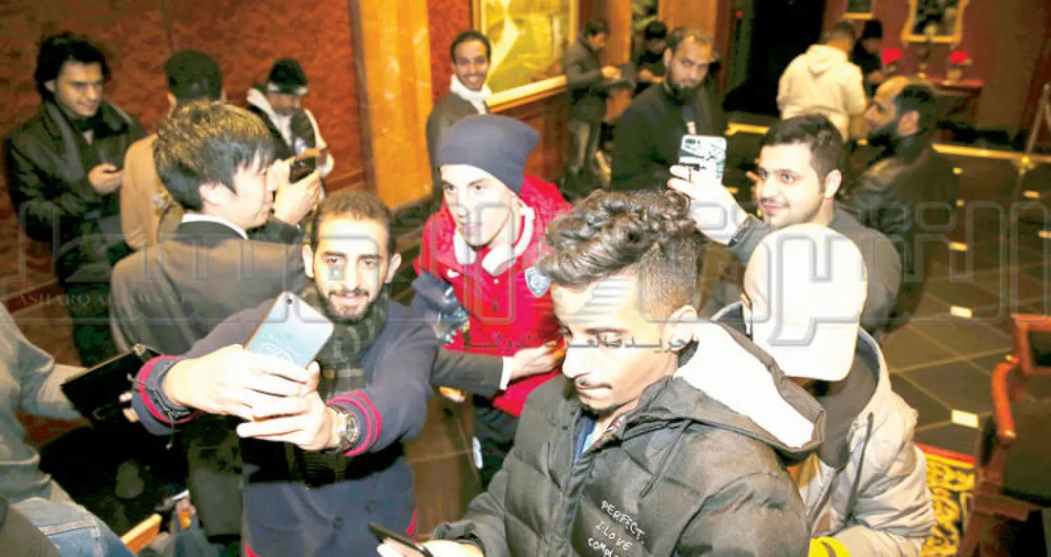 مشجعون هلاليون يلتقطون صورا مع البرازيلي ميليسي بمقر إقامة الفريق (تصوير: بدر الحمد)