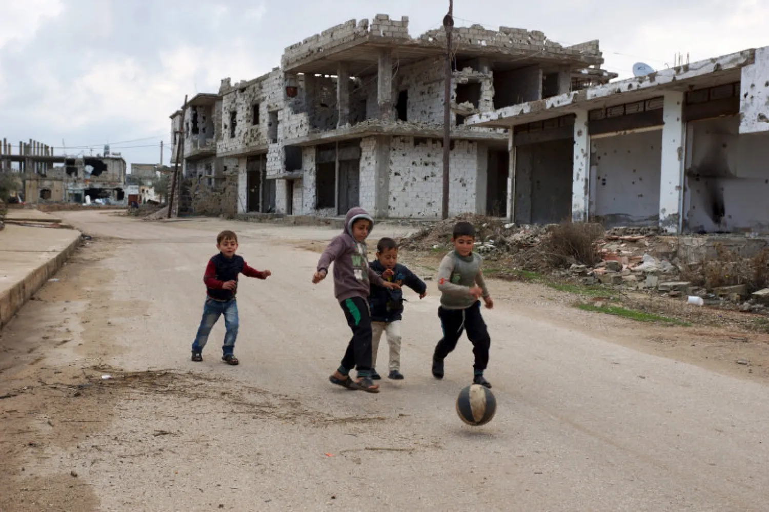 Children play near damaged buildings in the rebel-held southern town of Bosra al-Sham, Deraa, Syria. (Reuters)