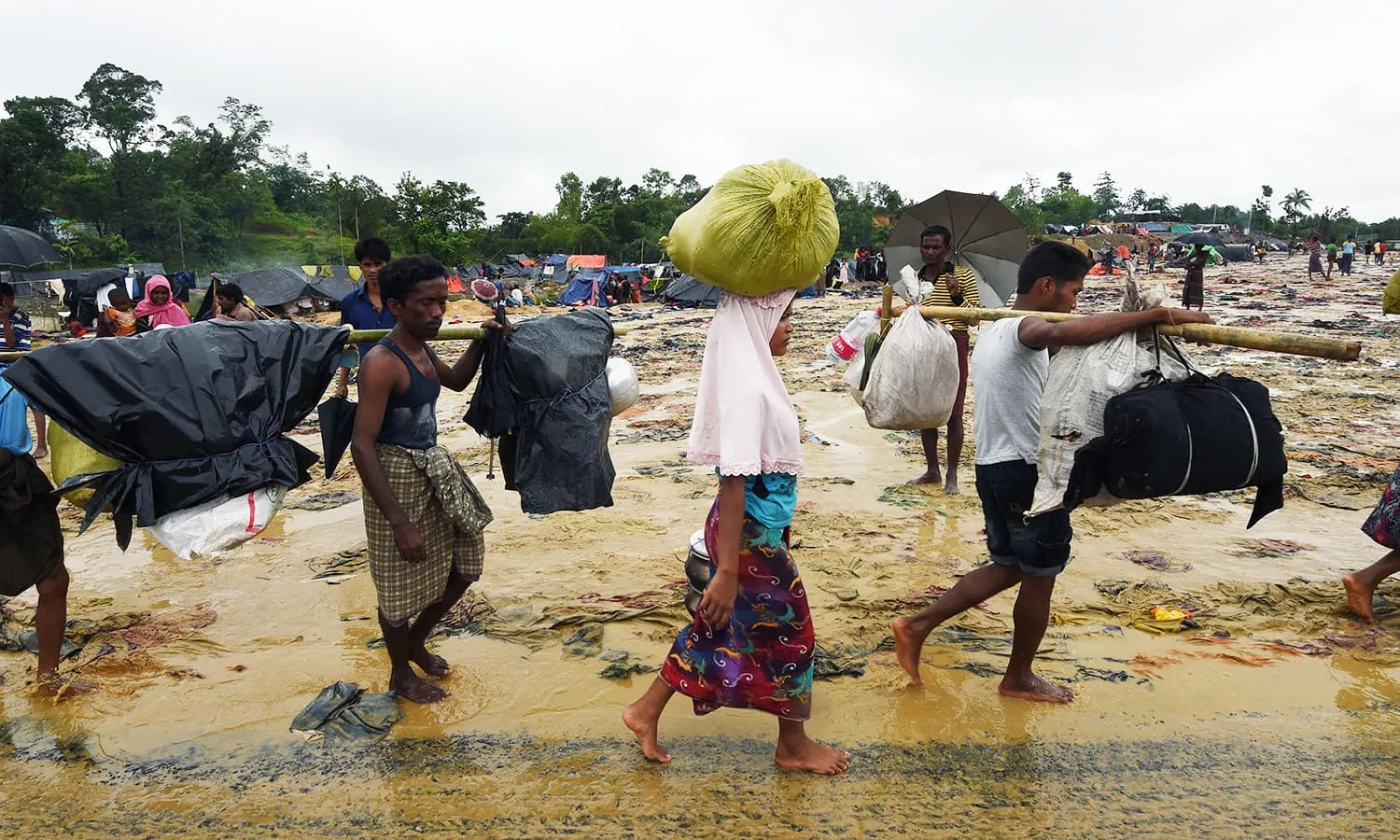 Rohingya refugees walk in the rain in Bangladesh's Balukhali refugee camp. AFP file photo