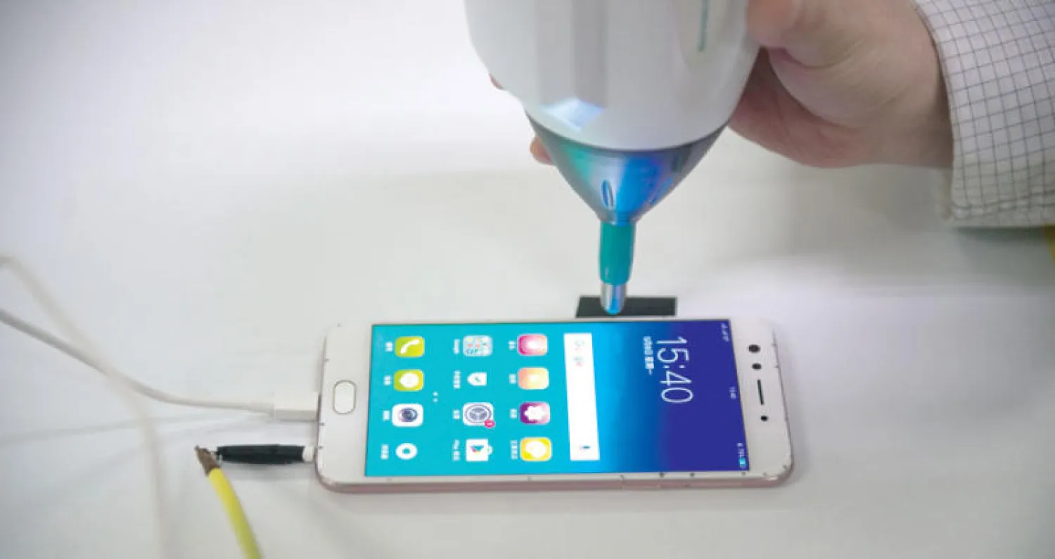 هاتف ذكي يتعرض لصدمة أثناء إجراء فحص له في حد مصانع مدينة دونغوان الصينية (غيتي)