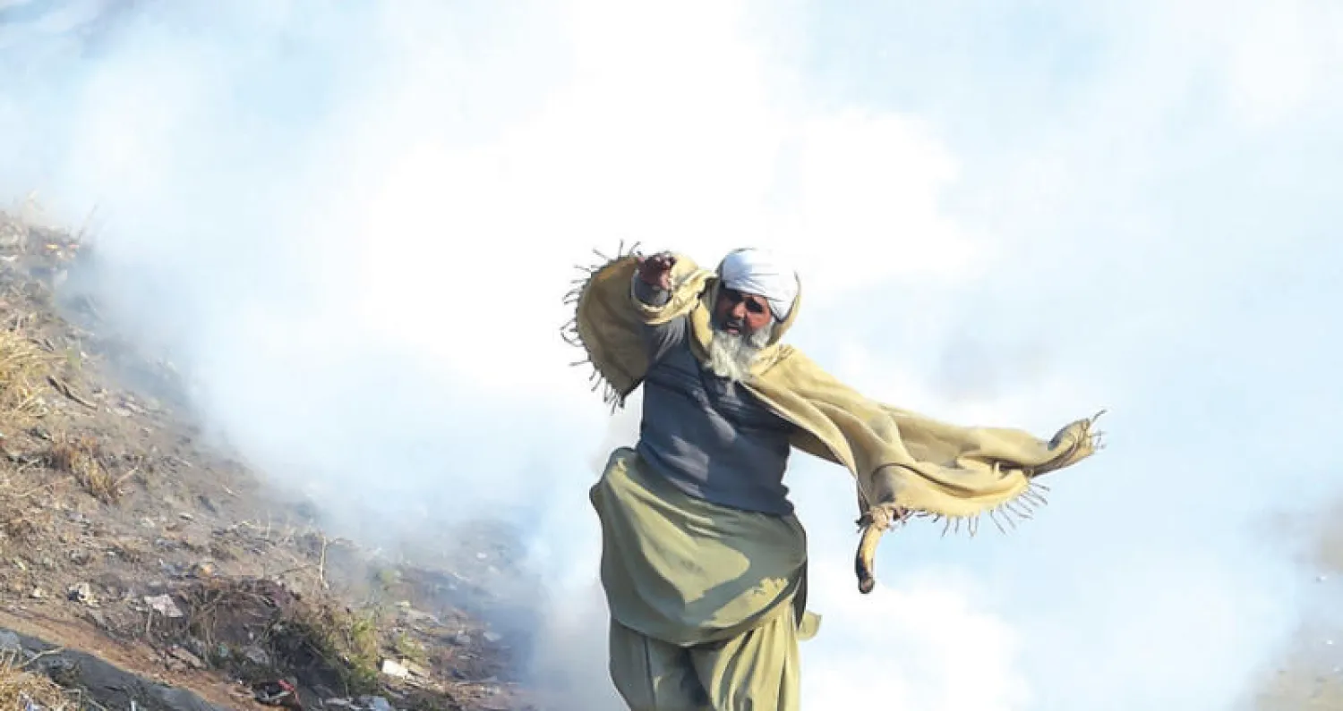 متظاهر خلال المواجهات مع الشرطة في إسلام آباد (أ.ف.ب)