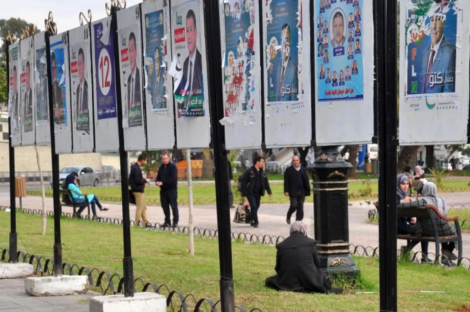 People stroll by electoral posters for the local elections, Wednesday, Nov.22, 2017 in Algiers. (AP Photo/Anis Belghoul)