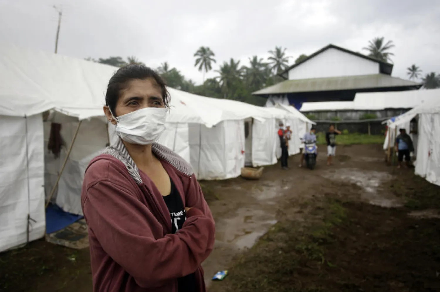 إمرأة إندونسية تقف في إحدى المناطق التي تم إخلاؤها بعد تحذير من بركان (أ.ب) 
