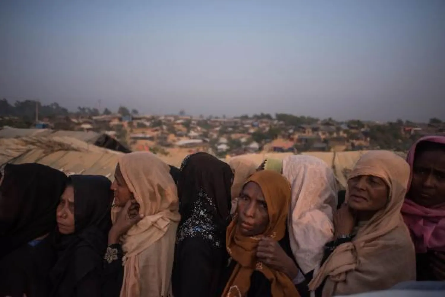 مسلمي الروهينغا في مخيم للاجئين ينتظرون مناداتهم للحصول على بعض الطعام. (أ.ف.ب)