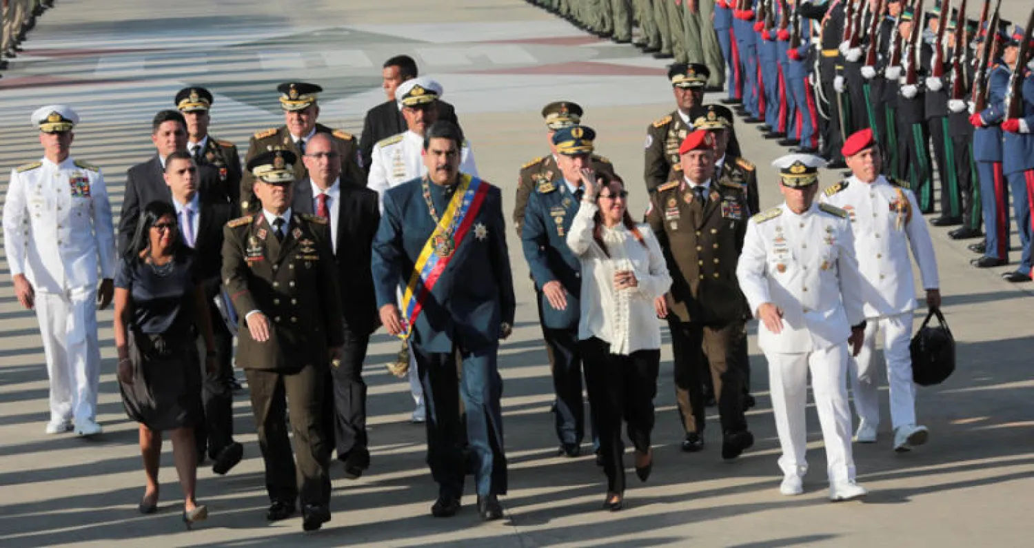 الرئيس الفنزويلي يتوسط عدداً من القيادات العسكرية في عرض عسكري بمدينة ماراكاي (رويترز)