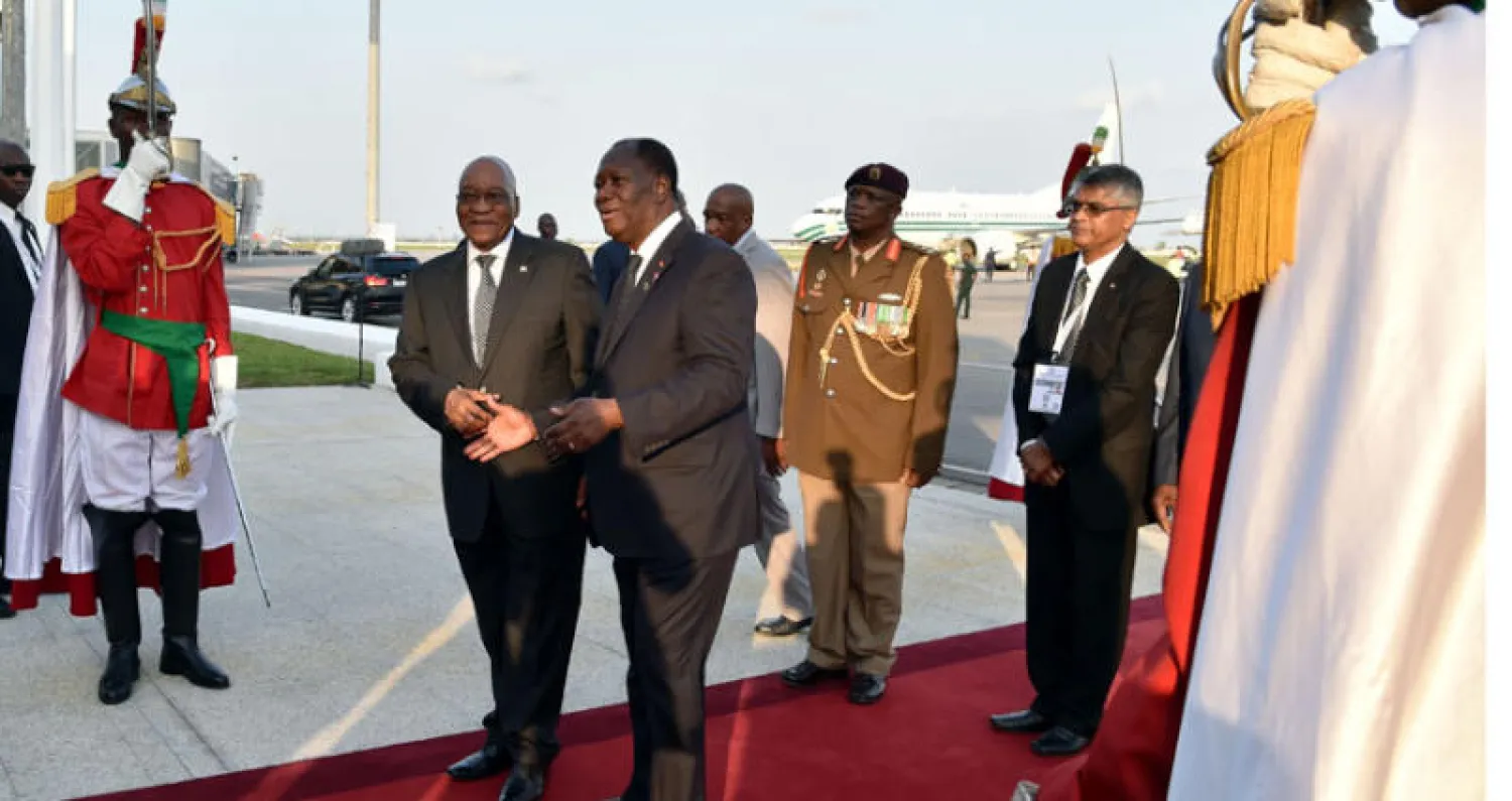 رئيس ساحل العاج مستقبلاً نظيره الجنوب أفريقي لدى وصوله إلى أبيدجان للمشاركة في القمة (أ.ف.ب)