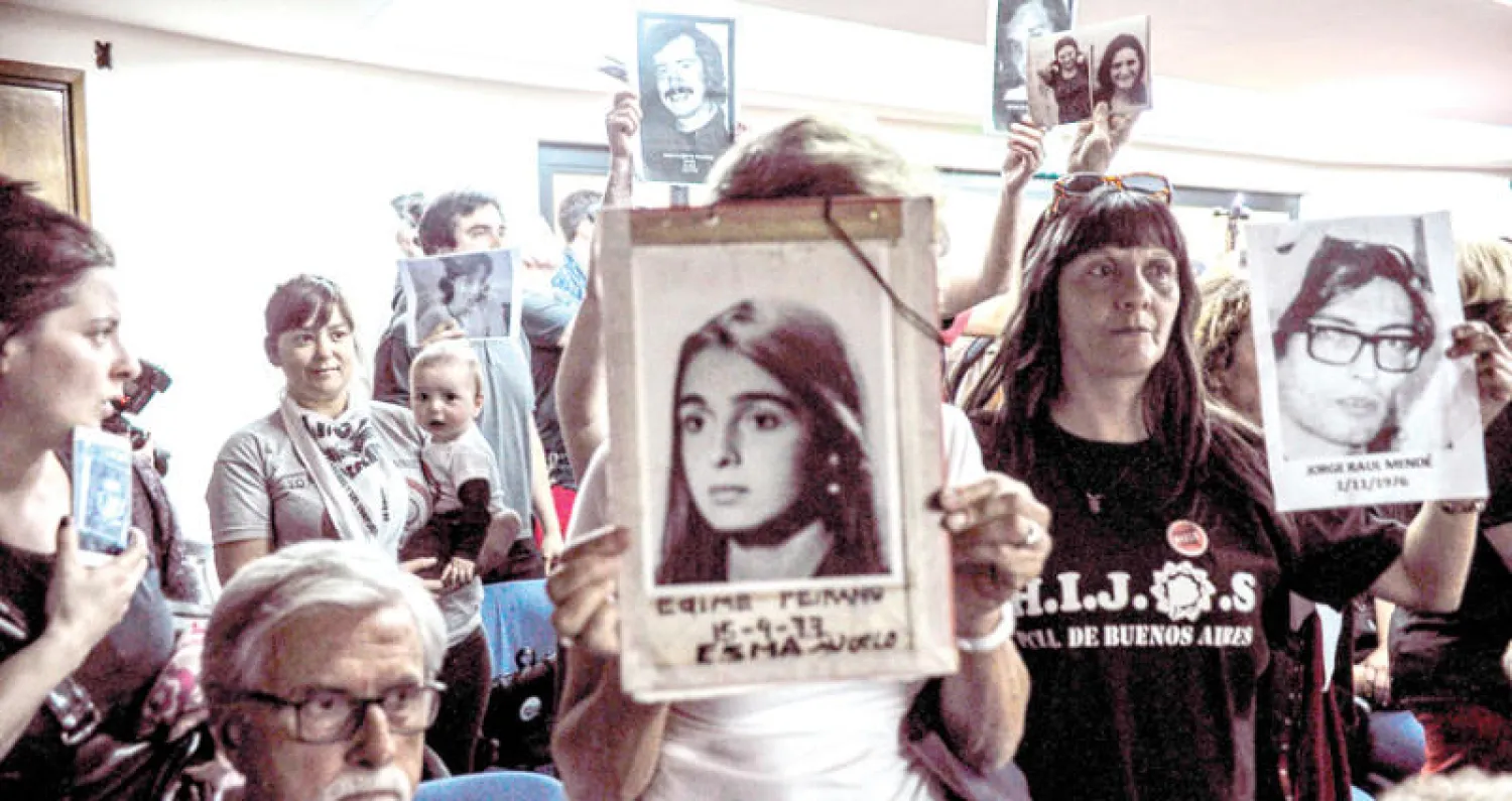 أقارب ضحايا الحقبة الديكتاتورية في الأرجنتين أثناء الانتظار خارج المحكمة (أ.ف.ب)