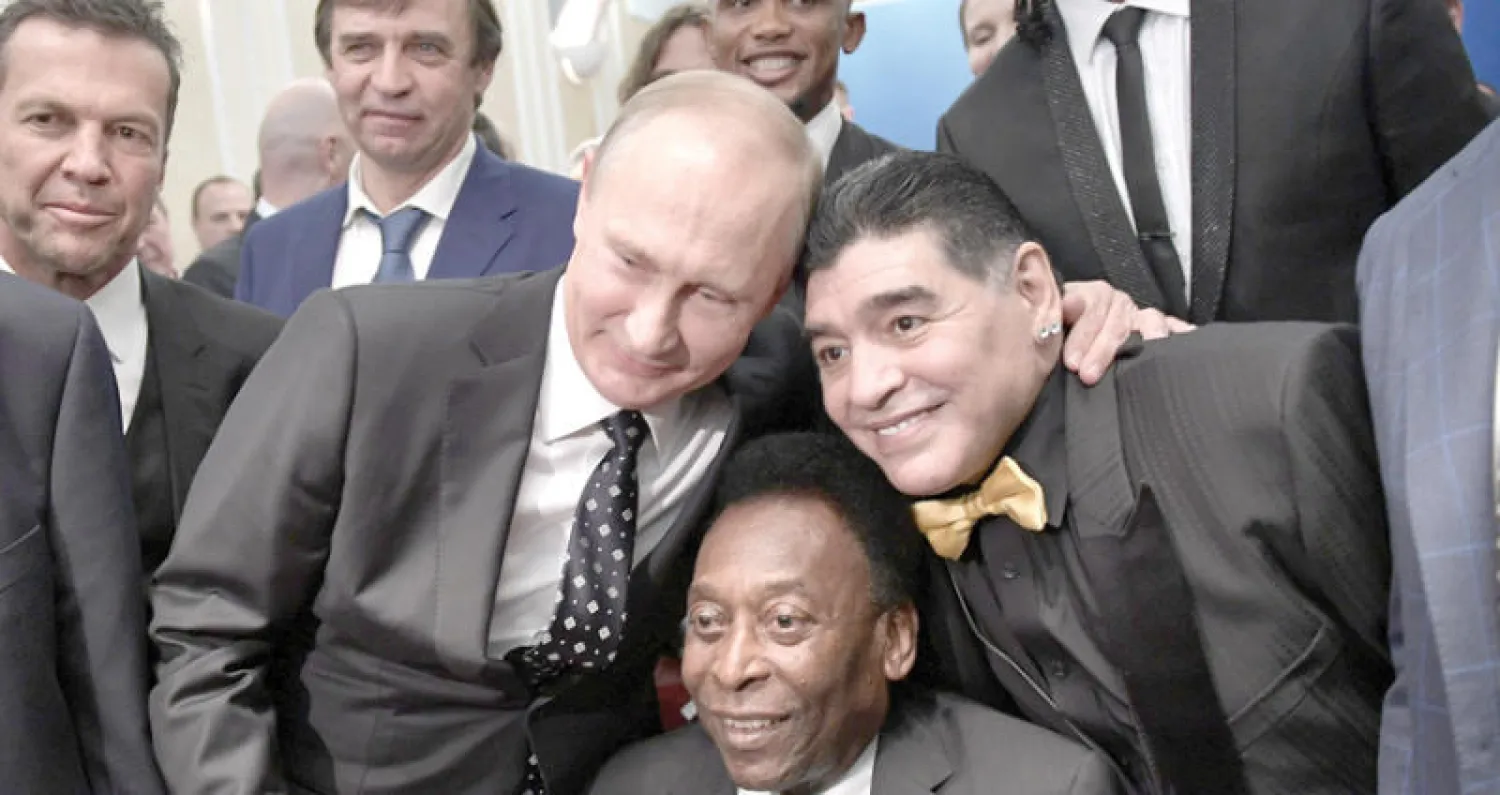 الرئيس الروسي فلاديمير بوتين يلتقط صورة مع أسطورتي كرة القدم البرازيلي بيليه والأرجنتيني دييغو مارادونا قبل سحب قرعة كأس العالم في الكرملين أمس (رويترز)