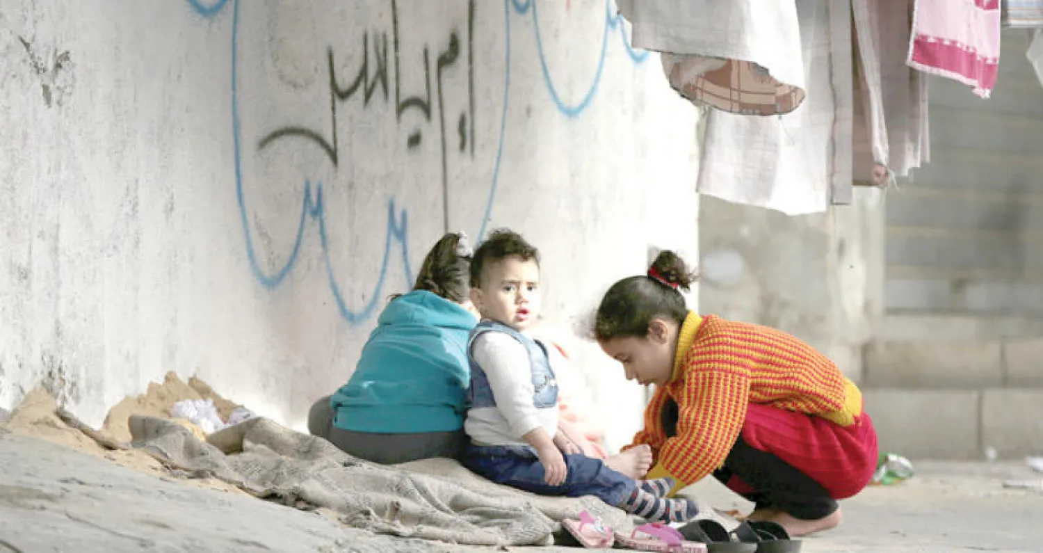 أطفال فلسطينيون يلعبون في مخيم النصيرات في غزة (إ.ب.أ)