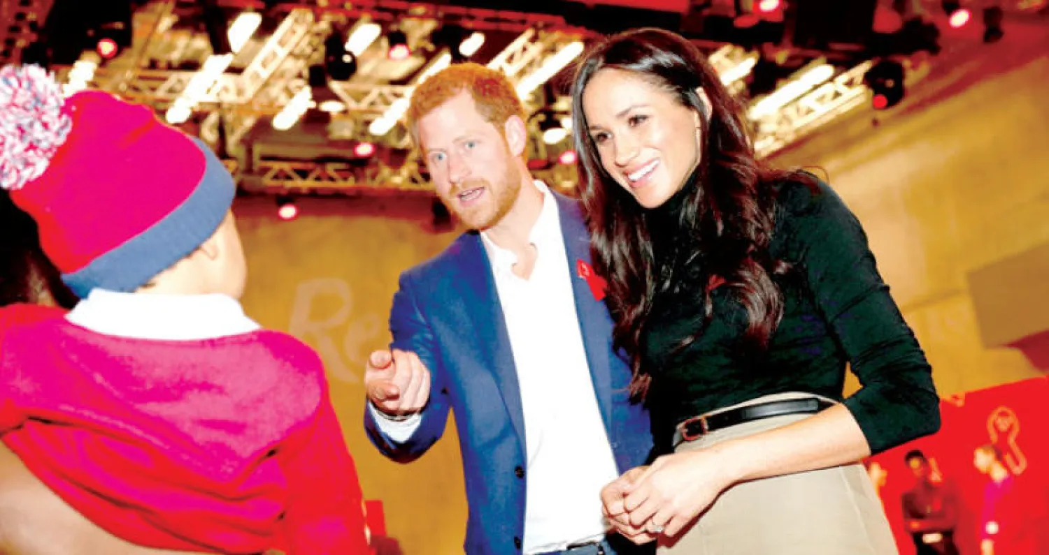 الأمير هاري وخطيبته ميغان أثناء حضورهما بازاراً خيرياً في اليوم العالمي للإيدز في نوتنغهام أمس (رويترز)