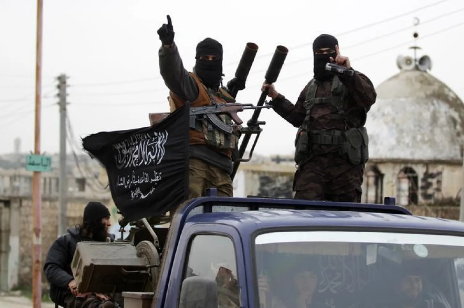 Members of al Qaeda's Nusra Front gesture as they drive in a convoy.  REUTERS/Khalil Ashawi
