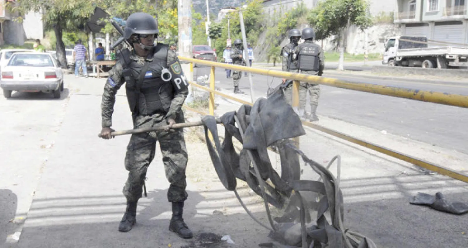 جندي ينظف آثار مظاهرات في العاصمة تيغوسيغالبا أول من أمس (إ.ب.أ)