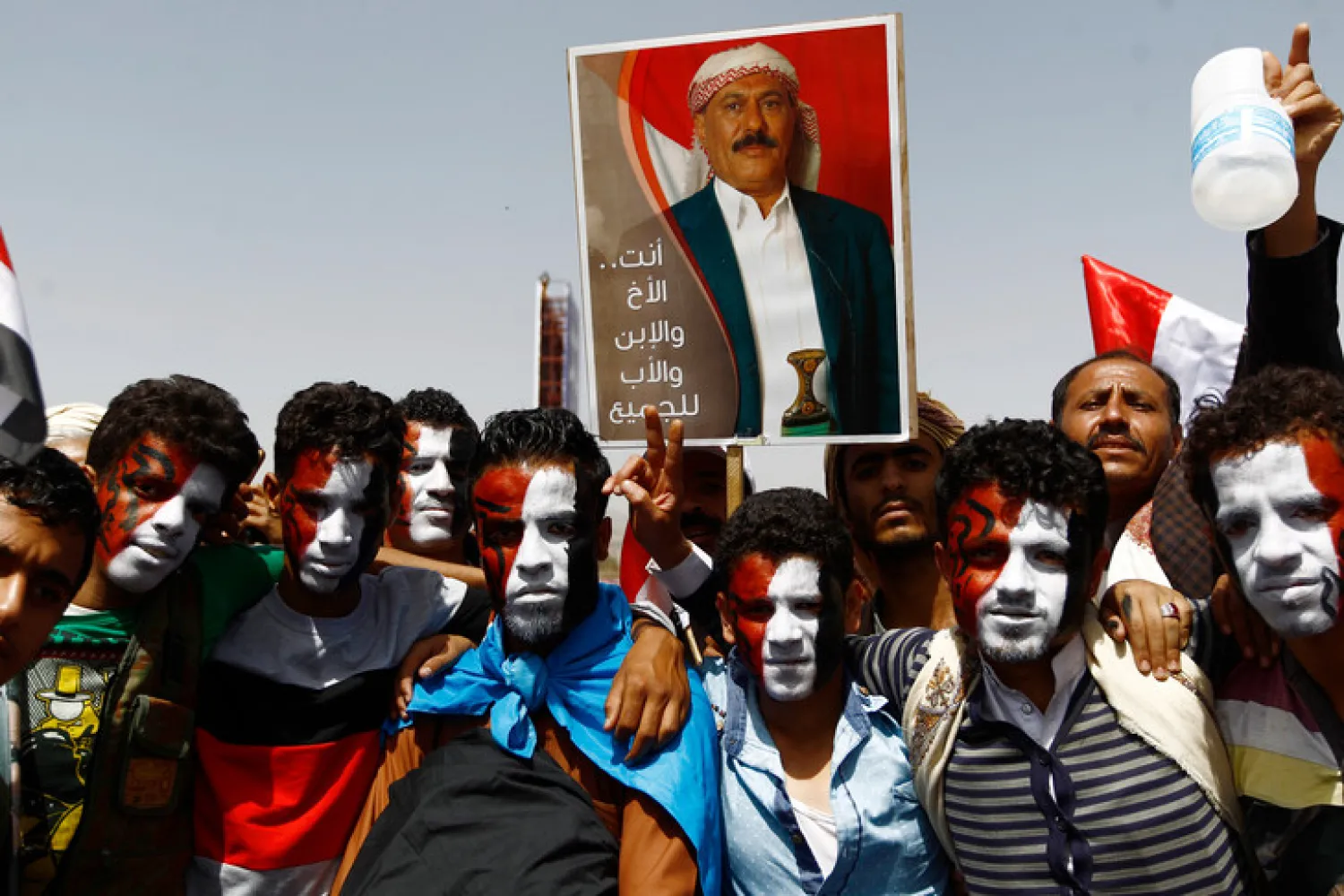 Yemenis raise the portrait of former President Ali Abdullah Saleh in Sana’a, March 2016. (AFP)