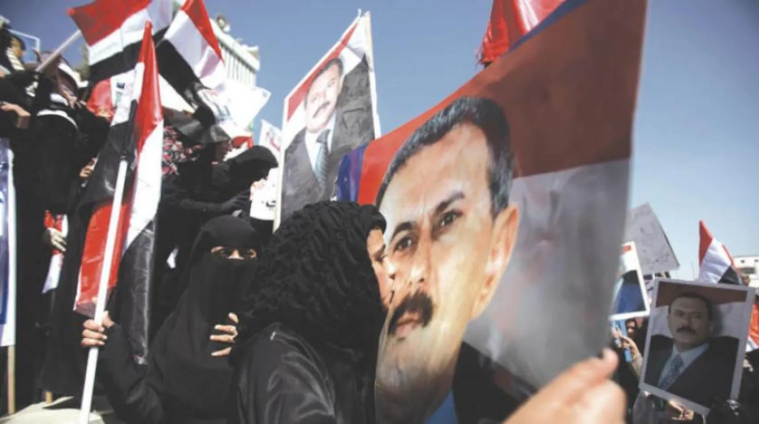 A Yemeni woman holds up a poster showing ex-president Ali Abdullah Saleh, Asharq Al-Awsat 
