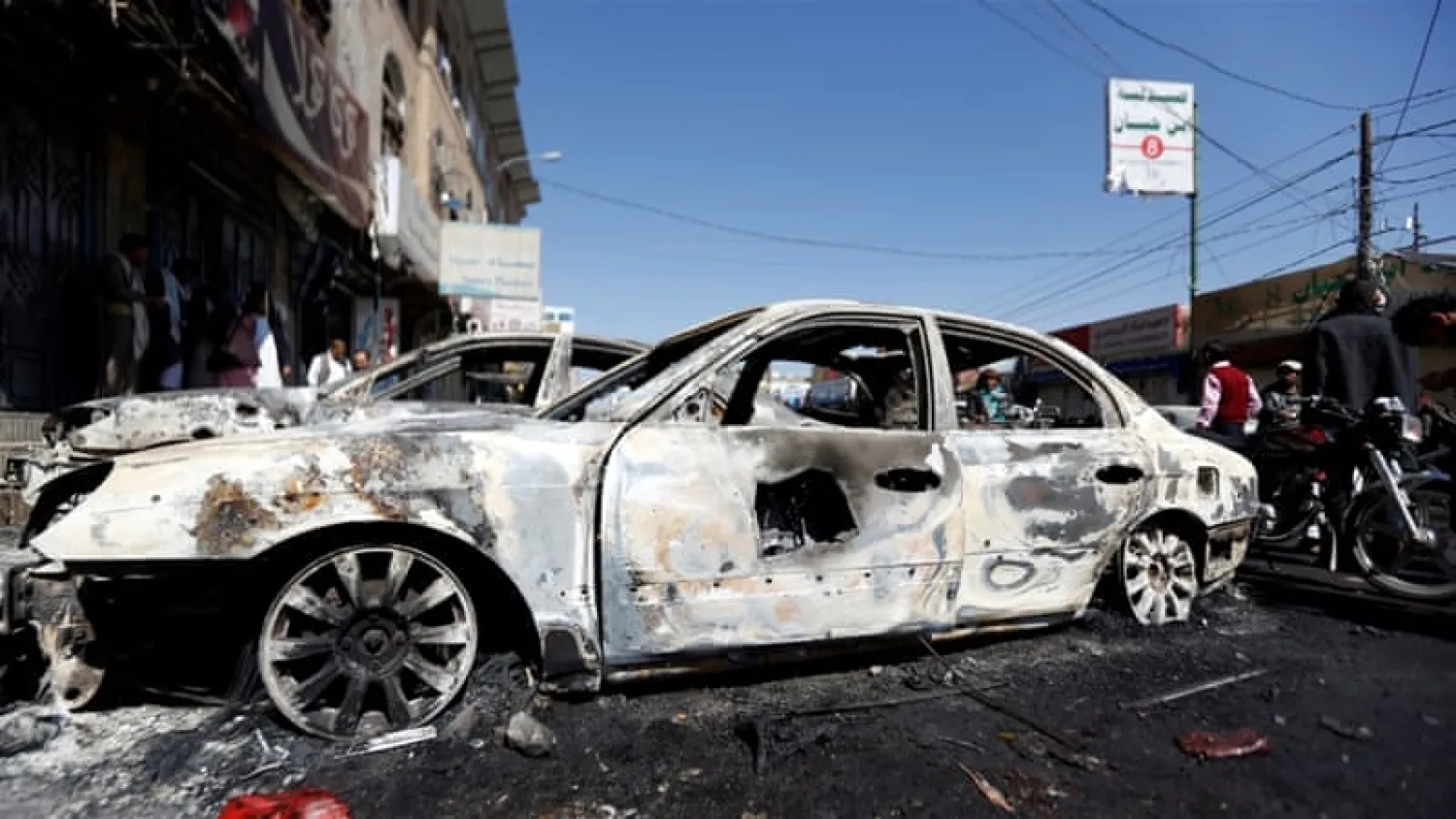 People go about their day near cars damaged during recent clashes between Houthis and forces loyal to Yemen's former president Ali Abdullah Saleh in Sana’a, Yemen December 5, 2017. REUTERS/Khaled Abdullah 