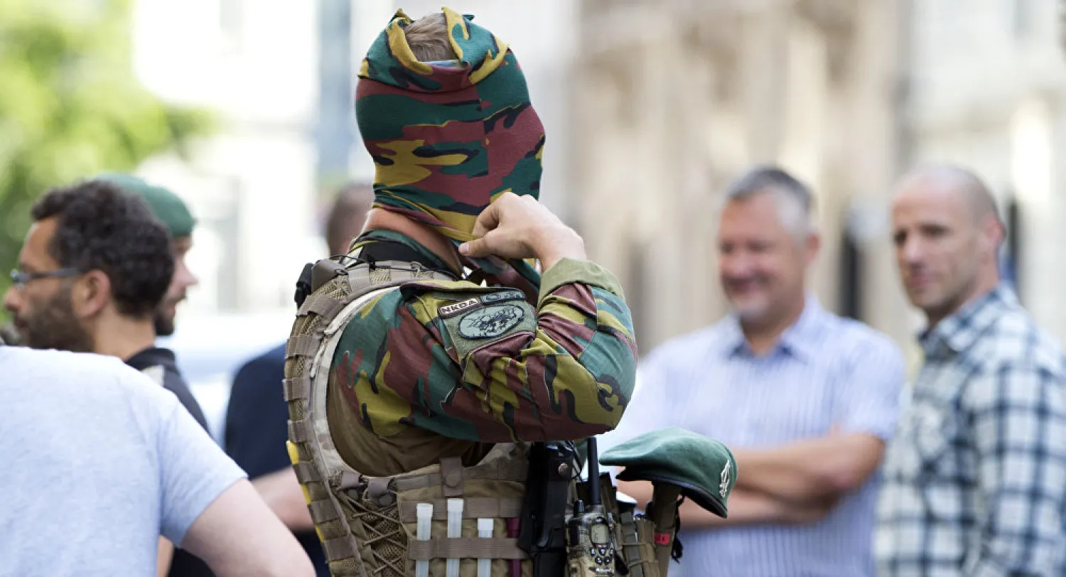 A Belgian soldier adjusts his face mask as he patrols outside the prime minister’s office in Brussels in June. (Virginia Mayo/AP)