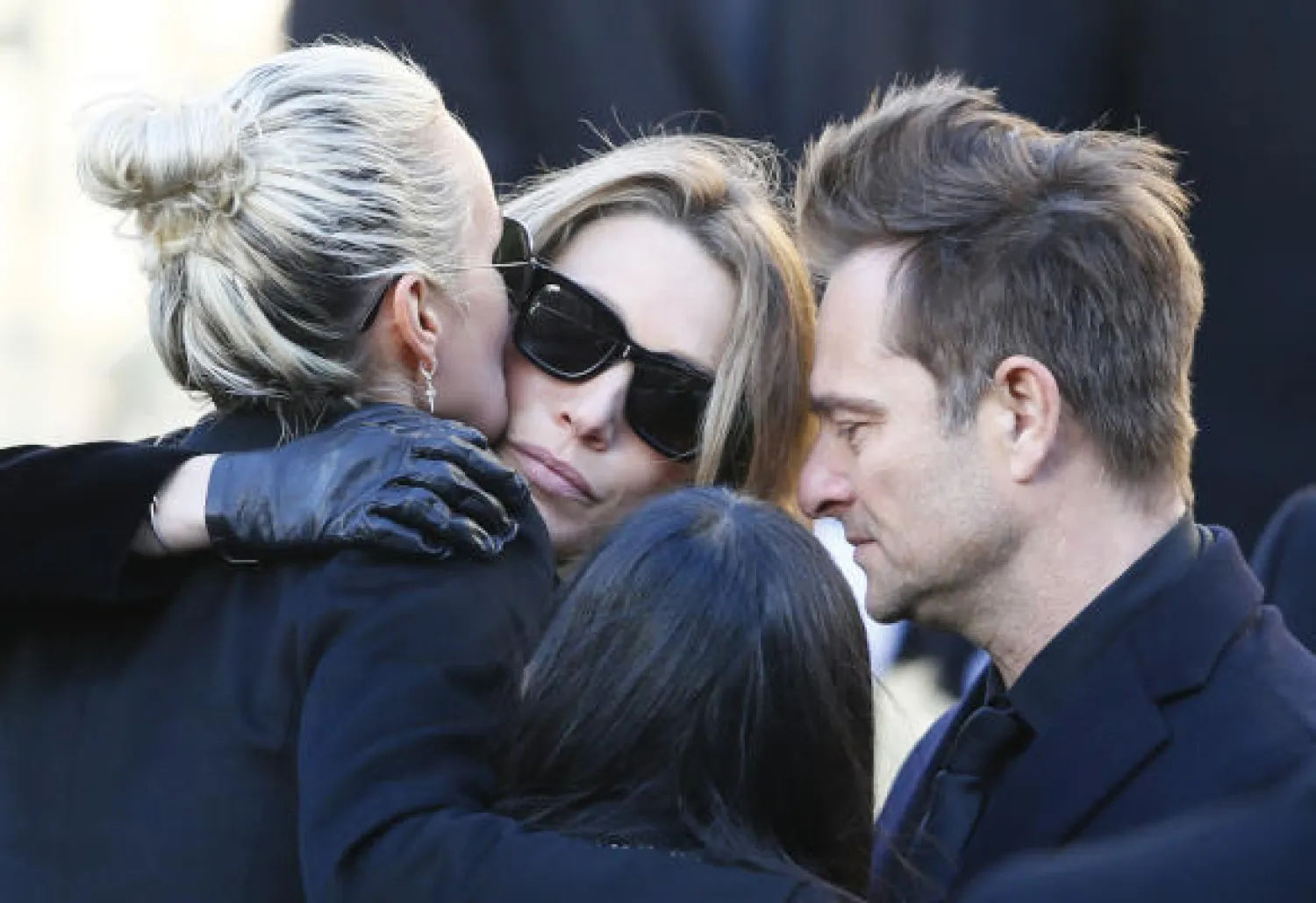 French rock star Johnny Hallyday's widow Laetitia, left, hugs Hallyday's daughter Laura Smet while his son David Hallyday react during Johnny Hallyday's funeral ceremony at La Madeleine church for Johnny Hallyday's funeral ceremony in Paris, Saturday, Dec.9, 2017. 