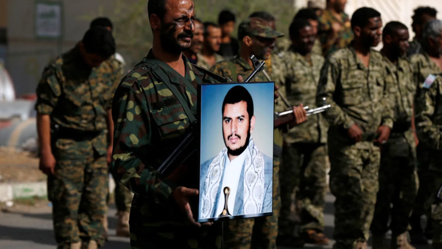 Newly recruited militant holds a poster of the Houthi movement's leader Abdulmalik al-Houthi. (Reuters)