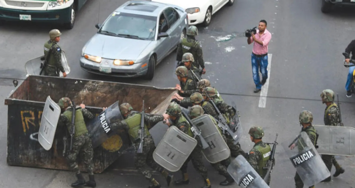 الشرطة ترفع حاوية من الطريق العام وضعها أنصار سلفادور نصر الله خلال الاحتجاجات التي دعت إليها المعارضة أمس (أ.ف.ب)