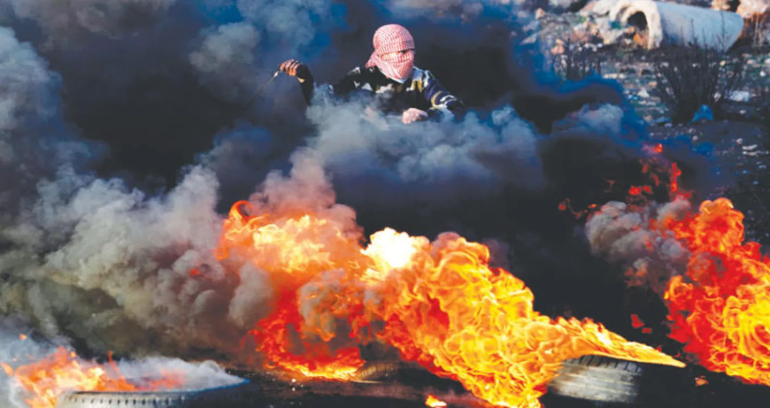 فلسطيني خلال اشتباكات مع قوات الاحتلال في رام الله أمس (أ.ف.ب)