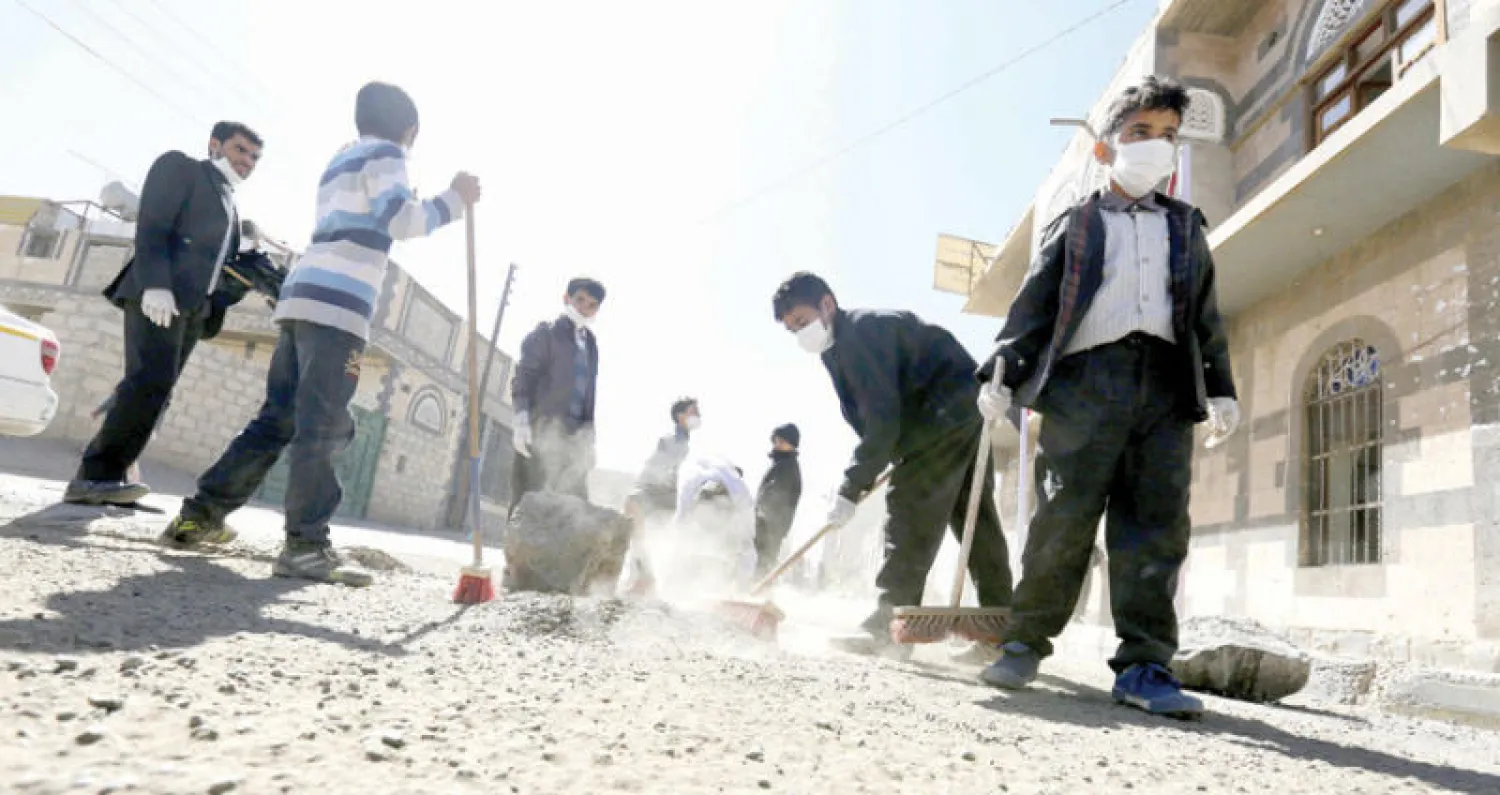 يمنيون تطوعوا لتنظيف شارعهم في صنعاء أمس (إ.ب.أ)