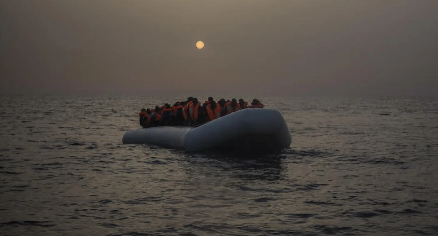 مجموعة من اللاجئين على متن قارب مطاطي ينتظرون الحصول على مساعدة قبالة الساحل الليبي (أ.ب)